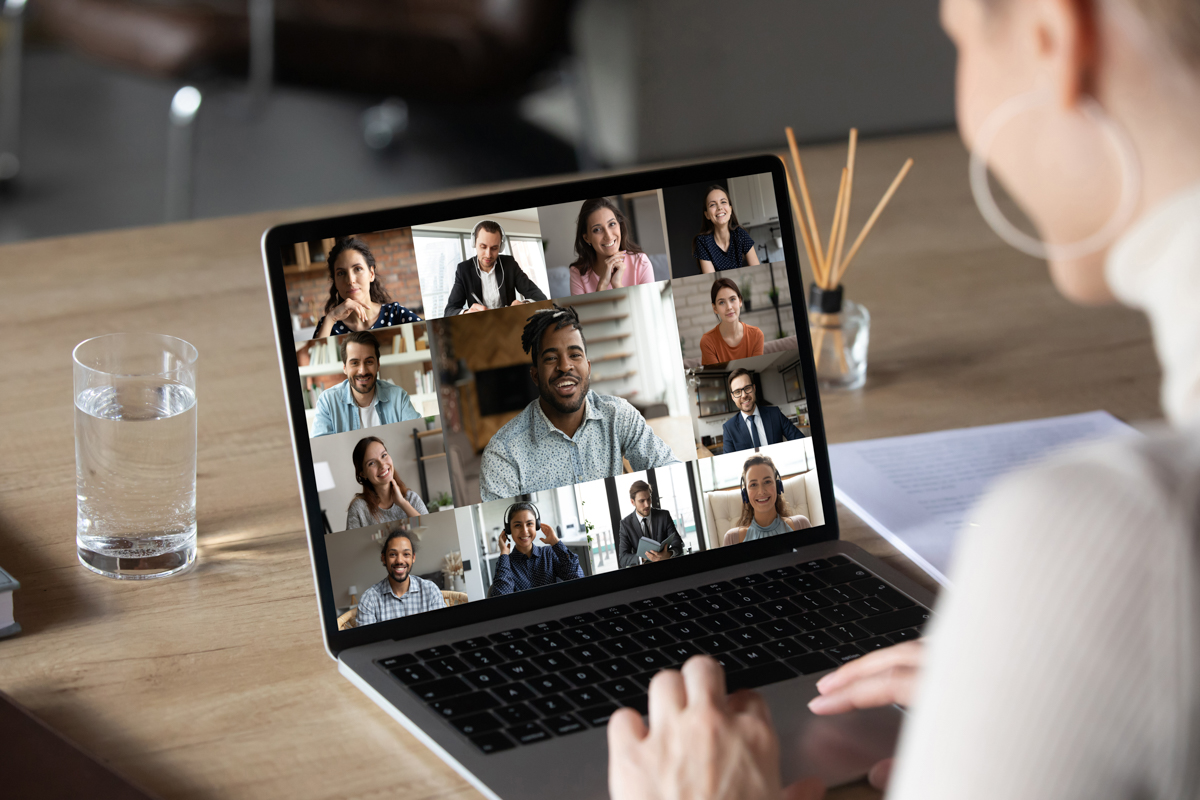 Smiling female employee using computer software application, holding video conference online call with multiracial colleagues and african american team leader, distant job business communication.